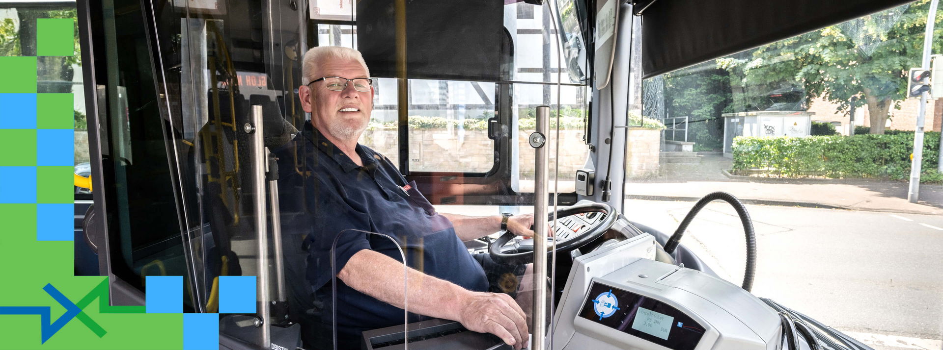 Ein Busfahrer im Führerhaus begrüßt seine Fahrgäste.